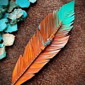 Cognac brown leather feather hat band with turquoise and paired with a flower charm