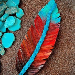 leather feather hat band decorated and painted in crimson, brown and with a turquoise blue braid.